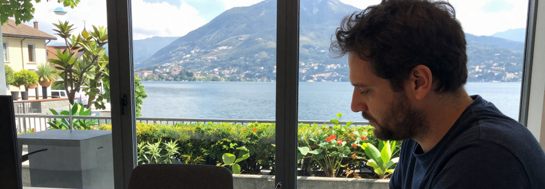 Client décrivant son projet de déménagement à Lugano auprès d'un conseiller Swidem, documents et notes sur table.