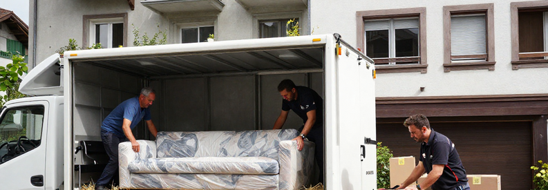 Demenagement Gossau Equipe Professionnelle Chargement Déménageurs professionnels chargeant mobilier et cartons dans camion devant immeuble à Gossau