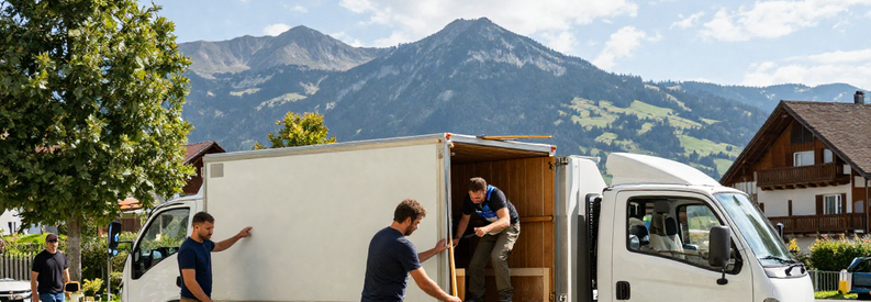Déménageurs professionnels devant immeuble de Kriens avec le Pilatus en arrière-plan, camion chargé