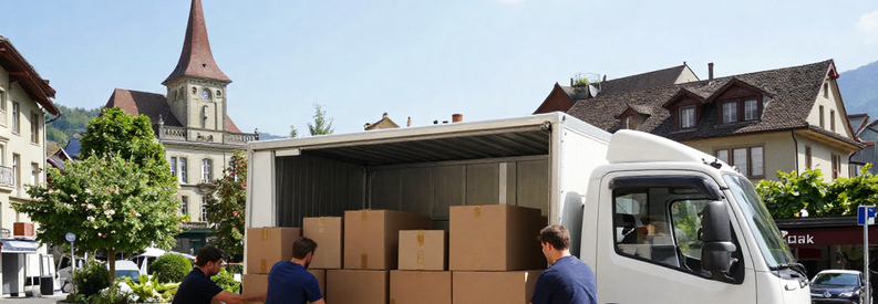 Demenagement Wil Saint Gall Demenageurs Immeuble Déménageurs professionnels chargeant un camion devant un immeuble résidentiel à Wil, canton de Saint-Gall